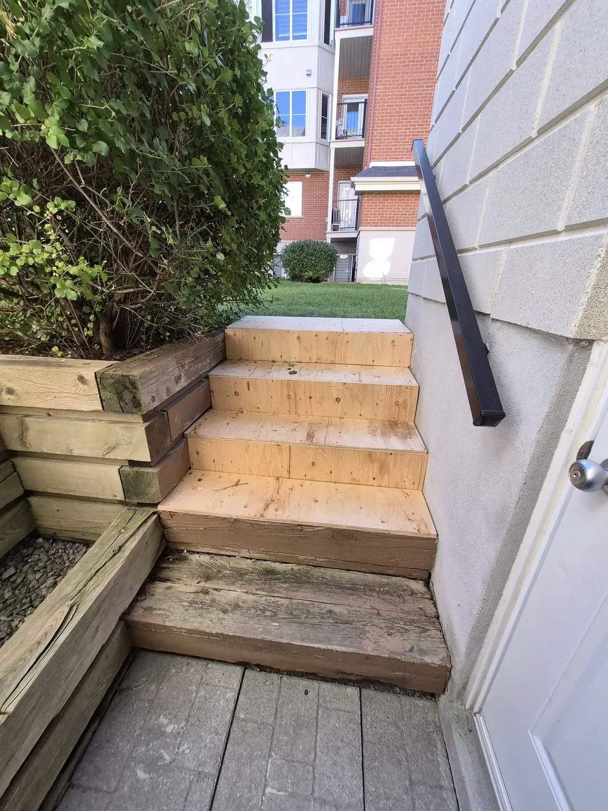 Escalier de bois refait menant à une porte de côté